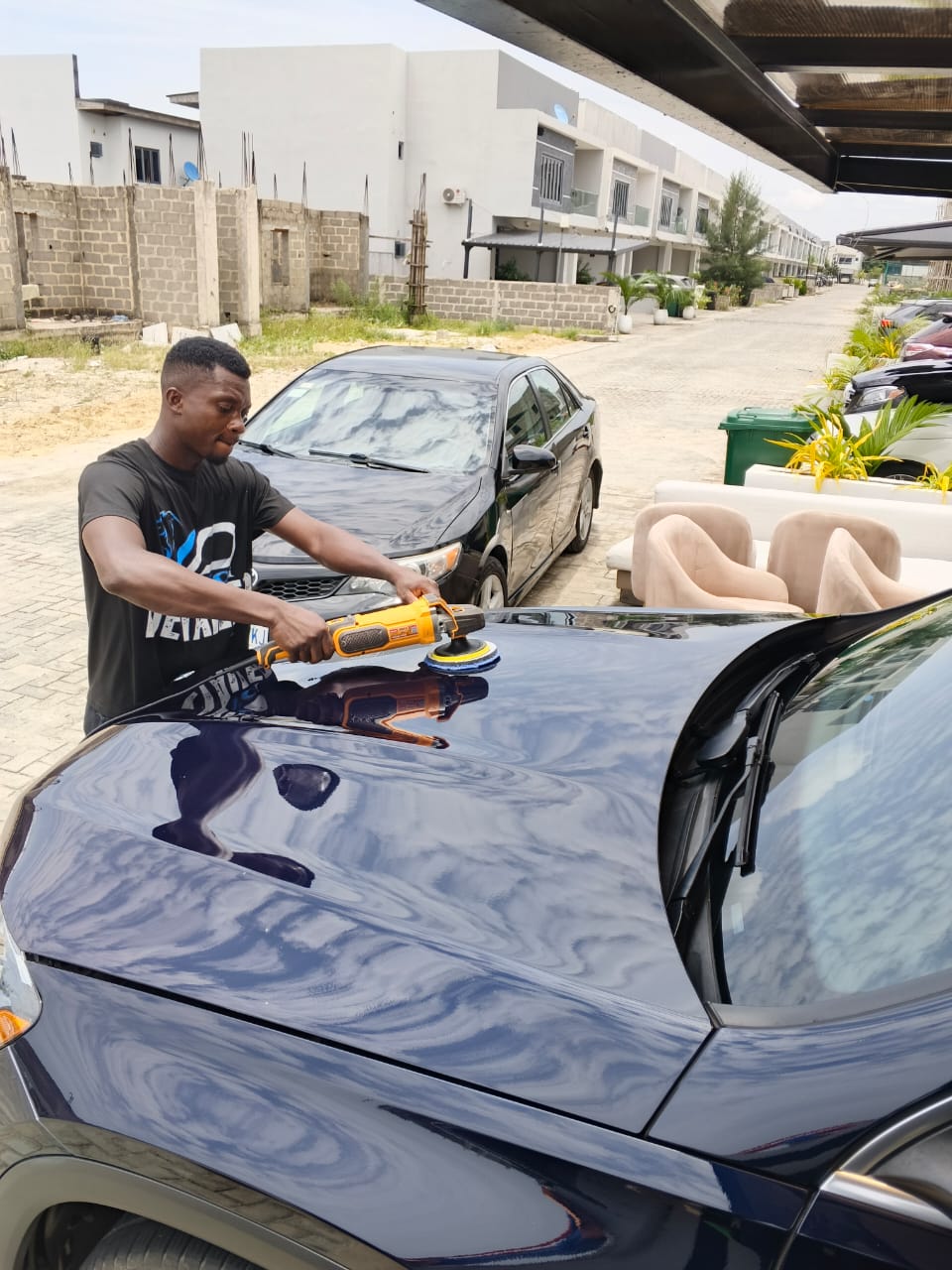 Man detailing a luxury car in Lagos